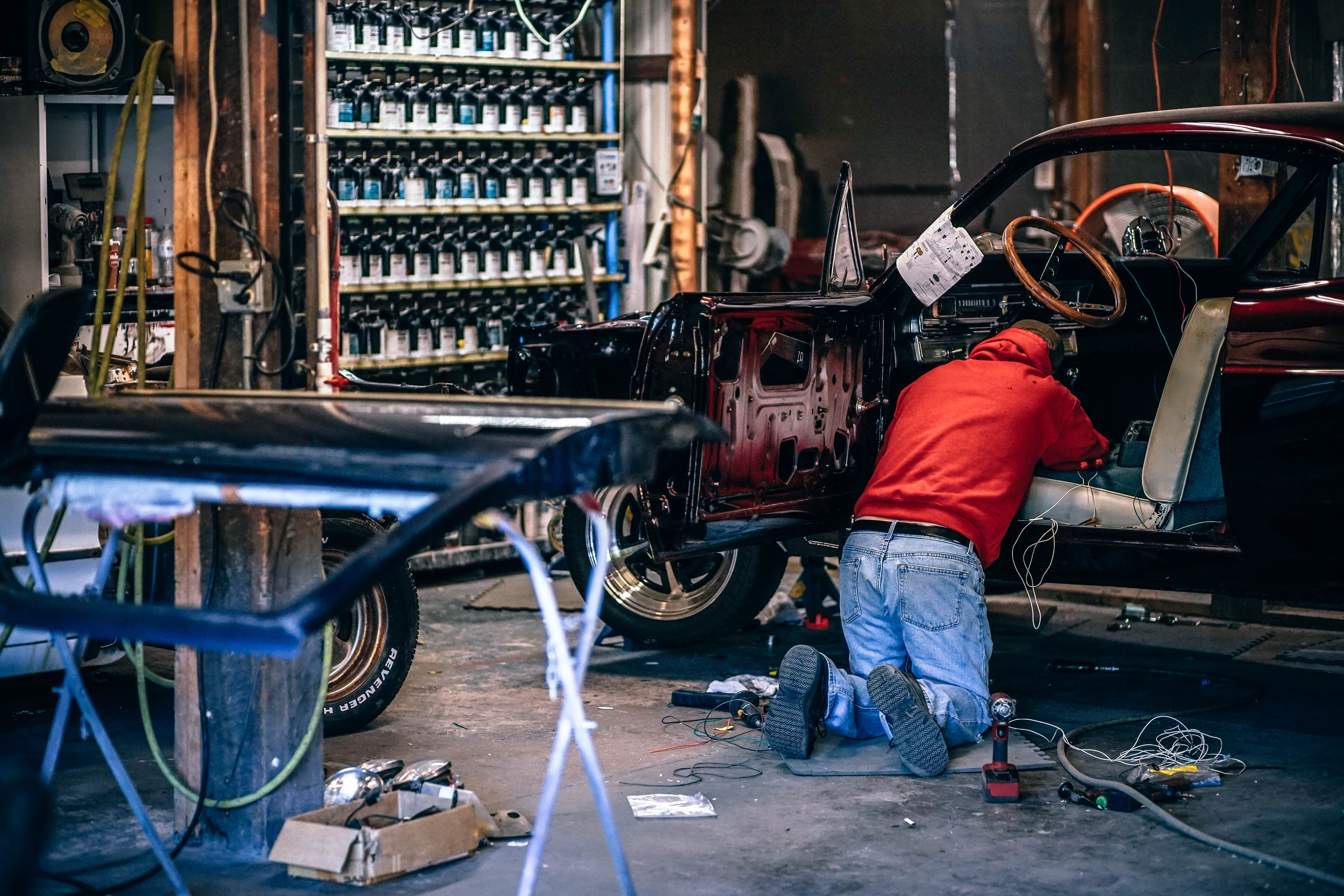 Mechanik při práci na automobilu v dílně